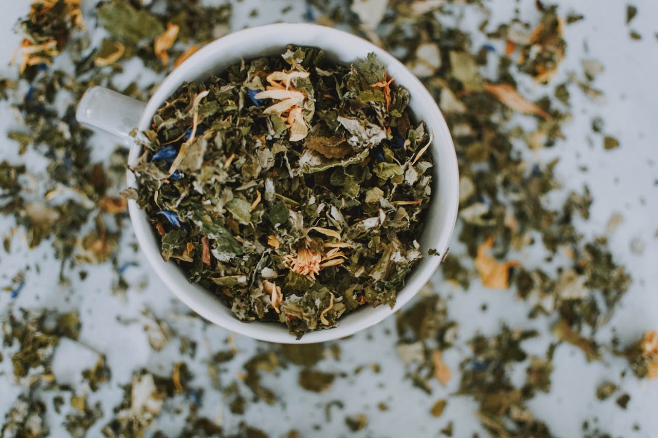 journey Overhead shot of a cup with a blend of dried herbal tea leaves and flowers.